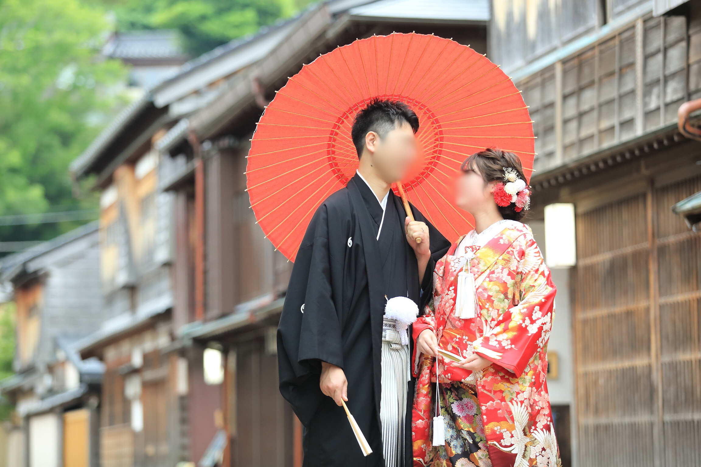 A photo of a couple in kimono holding a Japanese umbrella
